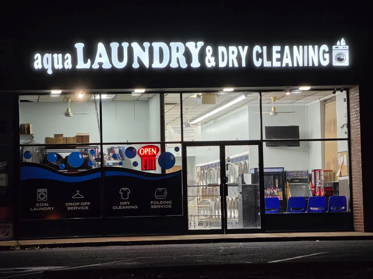 Aqualaundry & Dry Cleaning storefront lit up at night